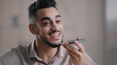 Mutlu İspanyol adam genç asistan cep telefonu kayıt ses mesajı cep telefonu hoparlör dijital çevirmen ses tanıma ayarları modern sanal yardım teknolojisi kavramını hatırlatır