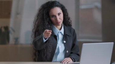 Etkileyici gülümseyen Arap bayan iş kadını takım lideri duygusal olarak kameranın işaret parmağıyla işaret parmağıyla konuşuyor. Hey sen, ofiste oturan İspanyol kadın işçi, seçimini yap. 