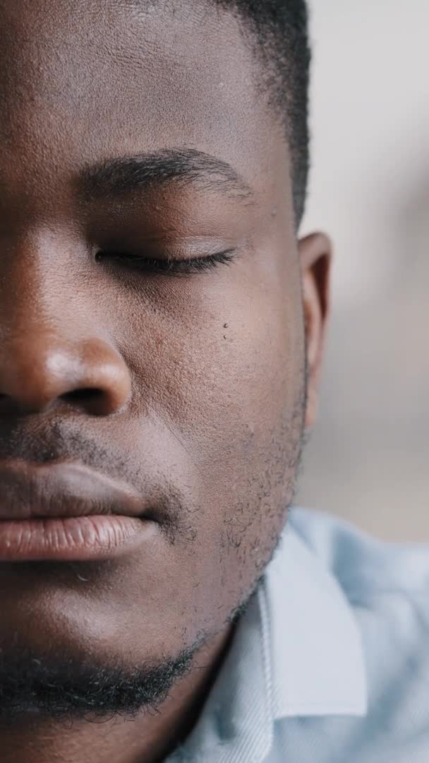 Vertikal vy allvarlig hälften man ansikte fokuserad vuxen afrikansk amerikansk man kille tusenårig modell koncentrerad ung affärsman djup blick stirrar på kameran med god syn närbild porträtt — Stockvideo