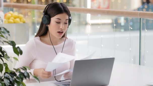 Aziatisch boos vrouw met papieren video call meisje dragen hoofd microfoon headset geschil ruzie ontevreden met documenten rapporten fout deadline werk problemen online conferentie met collega 's — Stockvideo