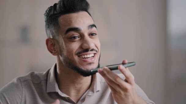 Ευτυχισμένος Ισπανόφωνος άντρας νεαρός βοηθός κατέχει κινητό αρχείο ομιλίας ηχητικό μήνυμα στο κινητό μεγάφωνο χρήση ψηφιακού μεταφραστή αναγνώριση φωνής θέτει υπενθύμιση σύγχρονη έννοια εικονικής βοήθειας τεχνολογίας — Αρχείο Βίντεο