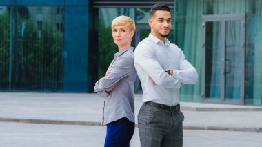 İspanyol iş adamı avukat müdür ve Kafkasyalı güzel iş kadını sekreter kısa saçlı kadın girişimciler açık havada durup kameraya bakarak poz veriyorlar.