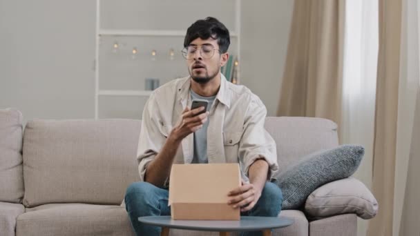 アラビア語不満消費者ブロガー男アンパッキングパッケージ注文ボックス録画ビデオブログストリームvlogで自宅不満を受け取る破損した間違った小包。悪いオンラインショップで失望した男性の問題 — ストック動画