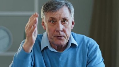 Şok olmuş yaşlı beyaz adam yaşlı olgun 60 'lı yılların erkeklerine şaşırdı. Endişeli erkek gözlüğü çıkardı. Kameraya baktı ve iş adamının gözlüğünü çıkardı.