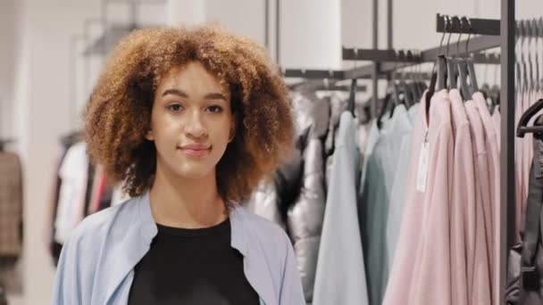 Afro-américaine fille heureux shopper consommateur acheteur bouclé femme client regardant caméra marche aller dans magasin de vêtements boutique avec panier paquet achat vente discount noir vendredi concept — Video