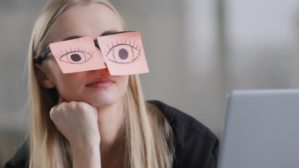 Tired female unmotivated manager with stickers on eyes sitting at desk sleeping at workplace chronic fatigue lazy businesswoman in office exhausted napping relaxing with sticky notes on eyeglasses — Vídeo de stock