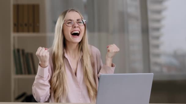 Joyful happy caucasian business woman girl winner lucky enjoy victory emotionally shouting winning with laptop online achievement offer bet computer game win success crazy shout sitting office table — Stock Video