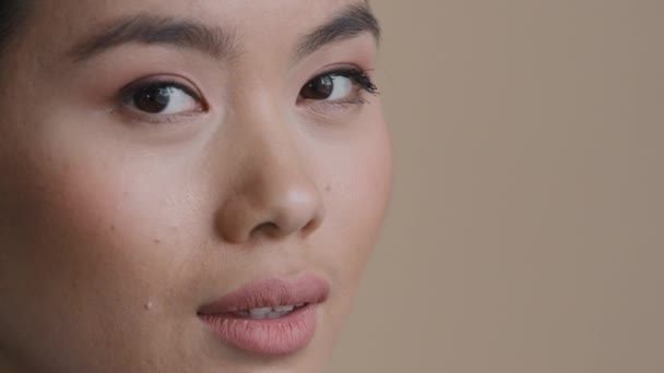 Ekstrem close-up kvindelige ansigt asiatiske race pige kosmetologi tjeneste klient tandpleje patient kvinde ser på kamera smilende toothy tænder sundhed vision syn korrektion hudpleje dermatologi – Stock-video
