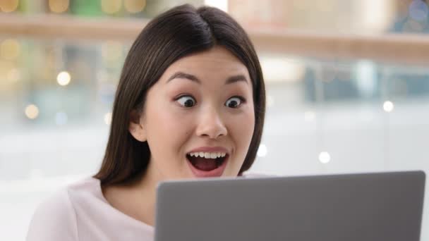 Overjoyed Asian woman wins achieves goal triumph says wow feels winner happy looking at laptop screen. Korean lady girl with computer receive job offer discounts event invite online victory close up — Stock Video