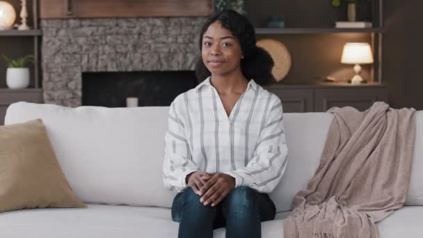 Afrikanerin Hausfrau Hausbesitzerin Mieterin Frau zu Hause im Wohnzimmer lächelt freundlich in die Kamera zufrieden mit dem Kauf neuer Immobilien. Psychologe sitzt im Büro auf Sofa — Stockvideo