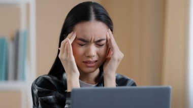 İyi olmayan Asya kökenli, Koreli, Çinli, milenyum iş kadını, yorgun, yorgun, yorucu, dizüstü bilgisayarı olan, yorgun, ağrılı, gergin, gergin, gergin, gergin, gergin, stresli bir iş kadını.