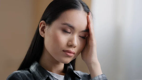 Złe uczucie azjatyckie dziewczyna millenium kobieta trudne myśli myśli myśli rozwiązuje problem masuje czoło z ręką czuje ból głowy cierpi na migreny ciśnienie przeciążenie pracy zmęczenie rozwiązanie wyszukiwania — Zdjęcie stockowe