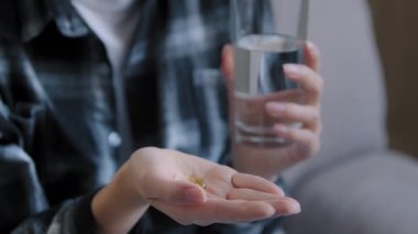 Tanımlanamayan yetişkin bir kadın elinde vitaminle kadın el hapları tutuyor hasta hamile kız eczanesi ve tedavi konsepti olan gıda takviyesi alıyor.