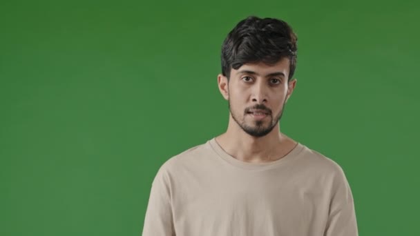 Portrét muže frustrovaný indické hispánský chlap mladý muž stojící nad zeleným pozadím čeká na setkání rozzlobený dospělý třesení hlavou s podrážděním ukazující prstem na zápěstí hodinky pozdě pozdě pozdě — Stock video