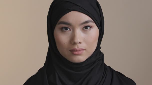 Portrait serious asian korea malaysian girl in black hijab traditional headscarf lonely muslim woman alone islamic female sad upset woman looking at camera indoors religious discrimination concept — Stok Video