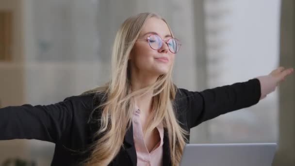 Caucasienne fille travailleur utilisateur secrétaire femme d'affaires dans des lunettes est assis les yeux fermés à la table avec ordinateur portable prétend être des rêves volants de vacances à l'étranger vent gonfle coup à cheveux dame bénéficie de la victoire — Video