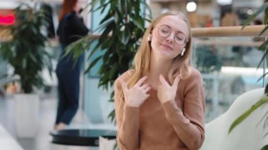 Kafkasyalı mutlu, aktif, müzik eşliğinde dans eden, müzik dinleyen, kablosuz kulaklıkla müzik dinleyen, ses uygulamasının tadını çıkaran, genç bir kadın, kapalı alanda hareket eden, şarkı söyleyen, kadın dansı yapıyor.
