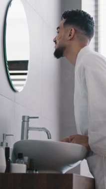 Dikey görüş, kendine güvenen Arap Hintli sakallı adam banyo sabahı motivasyonunda ayna yansımasına bakıyor. Yansıyan adamla konuşuyor. Narsist konuşma provası yapıyor.