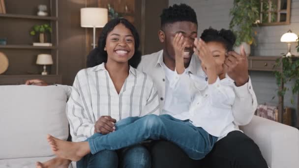 网络摄像头可以看到非洲快乐的家庭与摄像机视频交谈 从家里呼叫远程通信 父母和女儿坐在沙发上开会写博客 父亲和女儿在线Vlog — 图库视频影像