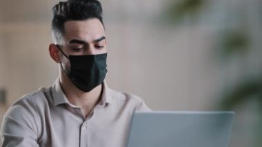 Tıbbi maske tasarımcısı Arap hasta bir işadamı, ağda dizüstü bilgisayarla arama bilgisini yazarken bulaşıcı koronavirüs salgını sırasında çevrimiçi sosyal uygulamalarda sohbet projesi geliştiriyor.