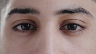 Aşırı yakın çekim erkek yüz genç Arap İspanyol yakışıklı manken adam ifade edici kahverengi gözlü kameraya bakan sağlıklı görme net optik görüş reklamcılık göz hekimliği operasyonu