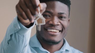 Coşkulu genç Afro-Amerikan erkek mutlu ev sahibi emlakçı piyangoda daire kazandı. Heyecanlı genç adam daire sahibi emlakçı. Yeni kiralık ev kredisinin anahtarlarını gösteriyor.