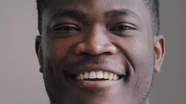 Gülümseyen yakışıklı afro-amerikan iş adamı neşeli bir yüz ifadesiyle kameraya bak erkek model dişlek dişçi reklamını Stomatolojik tedavi sonrası göster