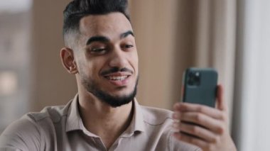 Mutlu İspanyol genç işadamı yakışıklı işadamı serbest çalışan gülümseyen adam akıllı telefondan konuşan uzaktan arkadaş sanal bir görüşme mesafesine sahip mobil sohbet iletişimi kablosuz bağlantısı var.
