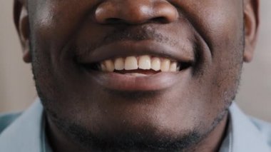 Aşırı yakın plan erkek yüzünün alt kısmı gülümseyen Afrikalı Amerikalı erkek müşteri anonsu yapan beyaz dişli baştan çıkarıcı dudaklar kamera kaydında web kamerası görüntüsü hakkında konuşuyor.