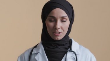 İslami Arap kadın doktor kardiyolog danışman kamerada görüntülü konuşma yapıyor genç Arap müslüman kız uzak öğretim servisini kullanıyor profesyonel danışman web kamerası görüntüsü veriyor