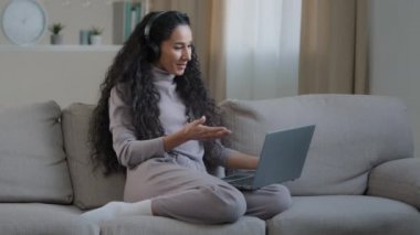 Mutlu gülümseyen genç, güzel, Arap kız, evde serbest çalışan. Kulaklık takıyor, sohbet videosu çekiyor. İnternet üzerinden arama yapıyor.