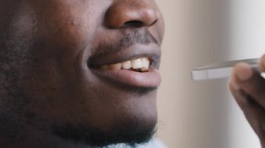 Erkek yüzünü kapat Afrikalı Amerikalı işçi ses kaydını kaydet akıllı telefon dijital çevirmen sohbetini sosyal uygulama konuşma bilgilerinde kullan hoparlörde metin yaz hatırlatıcı sanal yardım