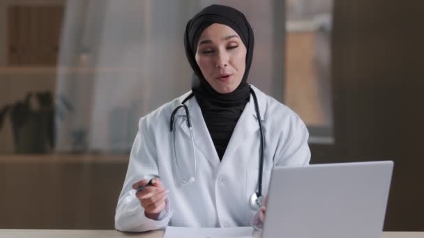 Médico Profesional Sonriente Psiquiatra Musulmán Cardiólogo Hijab Con Estetoscopio Sentarse — Vídeos de Stock