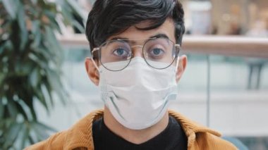 Tıbbi koruyucu maskeli mutlu erkek portresi. Kameraya bakıyor. Kafa sallıyor, anlaşma imzalıyor.