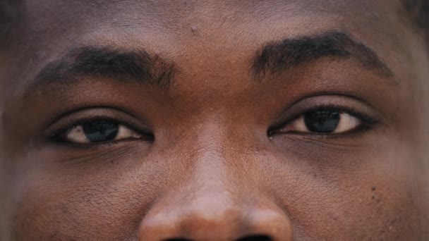 クローズアップ男性暗い悲しい目若いアフリカ系アメリカ人男性カメラビジョンの問題を見て視力ケアと手術サービス眼科クリニック広告レーザー補正レンズ製品店 — ストック動画