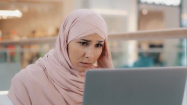 E-posta alan genç üzgün Arap kadın laptopta kötü haberler okuyor. Sağlık sorunlarını reddediyor. Banka krediyi reddettiğini bildiriyor.