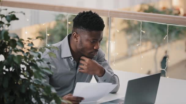 職場に座っている若い男性マネージャーノートパソコン上の正確性データをチェック真剣に困惑した集中的なビジネスマン文書検索情報を保持する解決策のための仕事の問題検索について考える — ストック動画