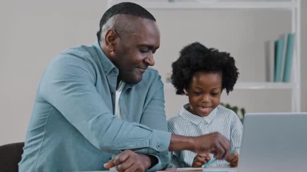 아프리카 미국인 아버지는 귀여운 숙제를 확인하는 줍니다 거실의 집에서 원격으로 — 비디오