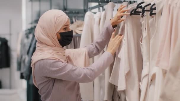 Jovem Concentrada Árabe Mulher Comprador Máscara Médica Vestindo Hijab Escolhe — Vídeo de Stock