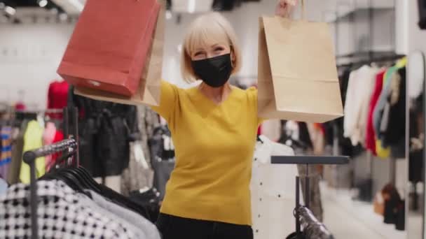 Ευτυχισμένη Χαρούμενη Ώριμη Γυναίκα Αγοραστής Ιατρική Προστατευτική Μάσκα Κατέχει Τσάντες — Αρχείο Βίντεο