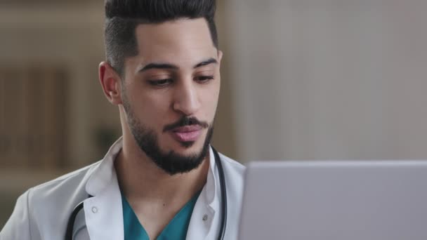ヒスパニック系男性心理学者アラブ医師医療アドバイザー男はキャビネットに座っているウェブカメラで精神療法セッションオンライントークを提供します — ストック動画