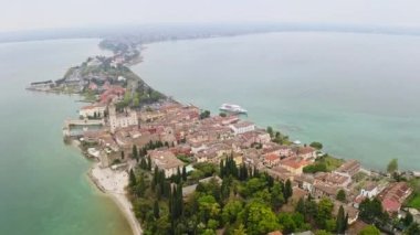 Garda Gölü 'ndeki tarihi Sirmione adasının havadan görünüşü. Göl yolculuğunun güneyindeki antik köy. Su aracının Rocca Scaliger kalesi üzerindeki doğal rezervuar şehri manzarası.