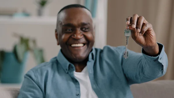 Portrait mature african american male happy homeowner showing keys to new apartment smiling looking at camera realtor real estate agent selling house bank loan buying modern home housing improvement