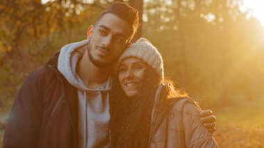 Dışarıda birbirini seven genç bir çift gün batımını seyrediyor gün batımını seyrediyor gülümsüyor ve gülüyor birlikte eğleniyor sevgili ve sevgili olarak keyifli sohbetler ediyor.