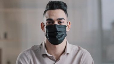 Arap erkek iş adamı İspanyol patron tıbbi yüz maskesi takıyor koruma maskesi takıyor viral hastalık Coronavirus semptomlarının yeni mesafe kurallarına uymasını önlüyor.