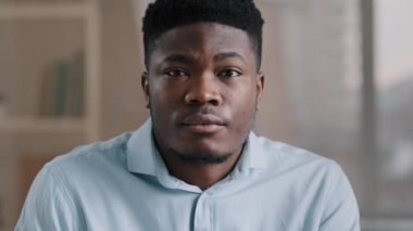 Odaklanmış Afro-Afrikalı iş adamı esmer, sakin, ciddi görüşü olan, yetişkin erkek, Amerikalı girişimci. Kapalı alanda poz veren kameraya bakın.