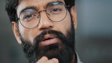 İspanyol portresi sakallı, esmer düşünceli, düşünceli, düşünceli, işadamı. Kapalı mekanda duran, çözümü düşünen, el ele tutuşan, çene öne çıkan, kamera paylaşım bilgilerini paylaşan adam.