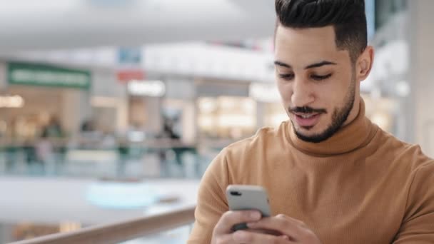 Close Mladý Arabsky Chlap Chodí Obchoďáku Drží Telefon Chatování Přáteli — Stock video