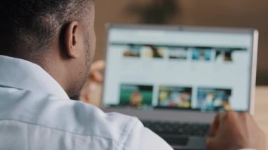 Erkek, tanınmayan Afrikalı erkek, Amerikalı genç web tasarımcısı, dizüstü bilgisayar ekran geliştirme online proje kaydırma internet sitesi sayfasına bakın. Modern arayüz seçildi.