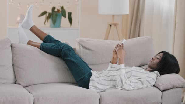 Young Carefree African American Woman Lazily Lying Sofa Room Resting — Stock Video